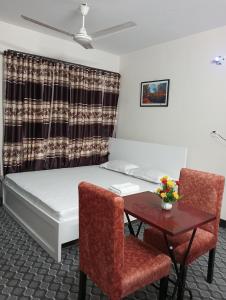 una camera con letto, tavolo e sedie di Hotel In Need - Near to the US and Canada Embassy in Dhaka a Dhaka