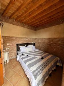 1 dormitorio con 1 cama grande en una pared de ladrillo en Riad BB Marrakech, en Marrakech