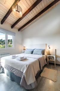1 dormitorio con 1 cama grande y techo de madera en Del Lago Departamentos en San Carlos de Bariloche