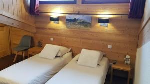 - une chambre avec deux lits, un bureau et une chaise dans l'établissement Le calme, le confort, la nature, skis aux pieds, à 15 kilomètres de Chamonix, à Vallorcine