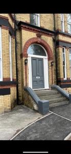 a door of a brick building with a bench in front at No 5 - LARGE 1 BED NEAR SEFTON PARK AND LARK LANE in Liverpool