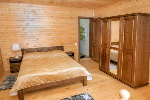 a bedroom with a bed and a wooden wall at Schale Centoriya in Mykulychyn