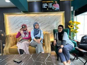 3 Frauen sitzen auf einer Couch im Laden in der Unterkunft SS Grey Hotel in Kuala Lumpur