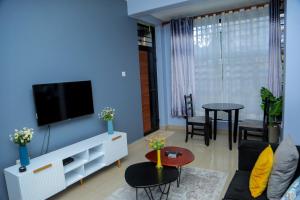 a living room with a blue wall at Pearl Sanctuary 01 Kiwatule, Kampala in Kira