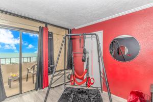 um quarto com uma parede vermelha e um tanque de oxigénio em Couples Retreat 409 em Myrtle Beach