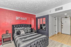 um quarto com uma cama e uma parede vermelha em Couples Retreat 409 em Myrtle Beach
