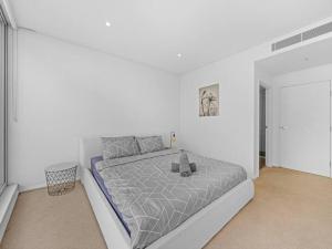 een witte slaapkamer met een groot bed. bij Lovely Apartment in the heart of Chinatown in Sydney