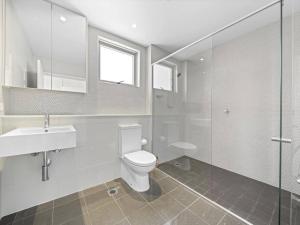 een badkamer met een toilet, een wastafel en een douche bij Lovely Apartment in the heart of Chinatown in Sydney