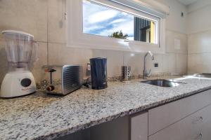 encimera de cocina con licuadora y fregadero en Del Lago Departamentos en San Carlos de Bariloche