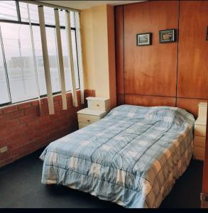 a bedroom with a bed and a brick wall at Alojamiento Punta Negra in Punta Negra
