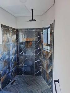 La salle de bains est pourvue d'une douche avec du carrelage bleu. dans l'établissement 14 on Lawrence, à Durban