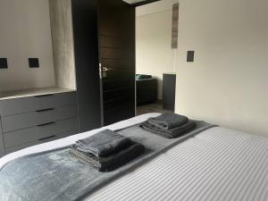 1 dormitorio con 1 cama con 2 toallas en 14 on Lawrence, en Durban