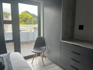 a bedroom with a chair in front of a window at 14 on Lawrence in Durban