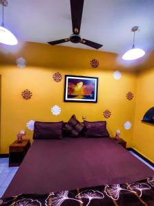 a bedroom with a large bed with a ceiling fan at Alor Elite Flats in Calangute
