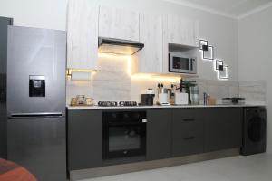 una cucina con piano cottura e frigorifero di Urbane- By LaSerene -Carlswald a Midrand