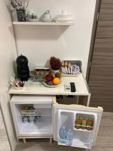 a small white refrigerator with food and fruit on it at Summer Beach Rooms in Fontane Bianche