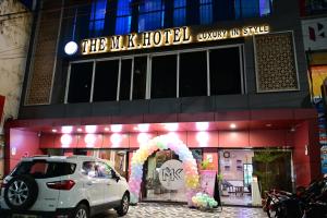 THE M K HOTEL -Luxury In Style في Chās: سيارة بيضاء متوقفة أمام الفندق