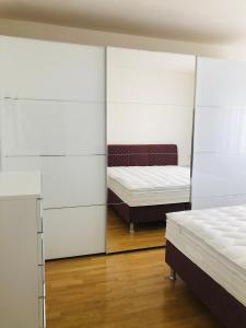 1 dormitorio con 2 camas y espejo en Appartamento Laura, en Merano