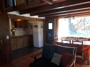 a living room with a couch and a kitchen at CABAÑAS SOLO POR HOY in Villa Pehuenia