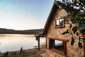 ビージャ・ペウエニアにあるCABAÑAS SOLO POR HOYの水の横に窓のある建物