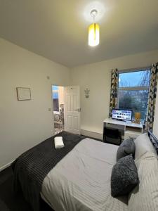Dormitorio con cama, escritorio y TV en Lovely Town house Room 3, en Parkside