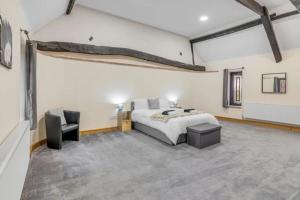 a large bedroom with a bed and a chair at amazing barn conversion with hot tub in North Walsham