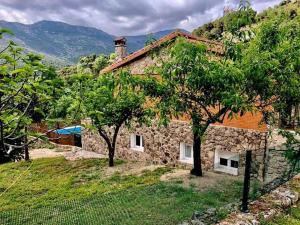 una casa de piedra con árboles delante de ella en Casa Balta, en Ávila