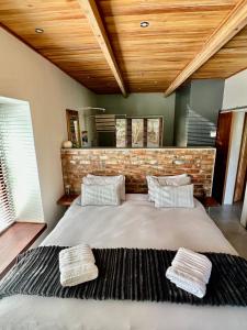 a bedroom with a large bed with two pillows at Swiss Chalet Clarens in Clarens