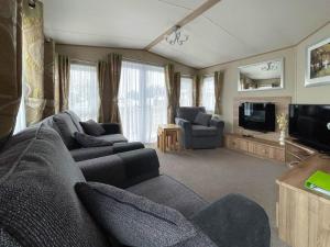 a living room with a couch and a tv at Beautiful 6 Berth Caravan With Decking At Valley Farm Holiday Park Ref 46736v in Great Clacton