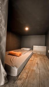 Bett in einem Zimmer mit Holzboden in der Unterkunft Resting Rabbit Hostel in Siquijor