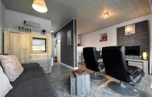 ein Wohnzimmer mit einem Sofa und Stühlen sowie ein Schlafzimmer in der Unterkunft Amazing Apartment In De Haan With Wifi in De Haan