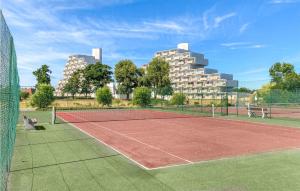 einen Tennisplatz mit Gebäuden im Hintergrund in der Unterkunft Amazing Apartment In De Haan With Wifi in De Haan