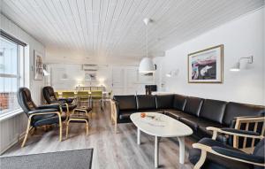 ein Wohnzimmer mit einem Sofa, Stühlen und einem Tisch in der Unterkunft Gorgeous Home In Blvand With Sauna in Blåvand