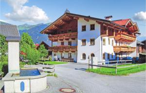 ツェル・アム・ツィラーにあるNice Apartment In Hainzenberg With House A Mountain Viewの木製バルコニー付きの白い大きな建物