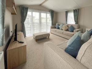 a living room with two couches and a tv at Beautiful 8 Berth Caravan With Decking At Naze Marine Park, Essex Ref 17184p in Walton-on-the-Naze