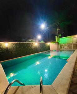 a swimming pool at night with lights at Perequê Praia Hotel in Porto Belo