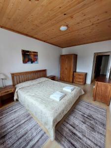 - une chambre avec un lit et un plafond en bois dans l'établissement Pamporovo Rhodopi Pearl Apartments - Private Apartments, à Pamporovo