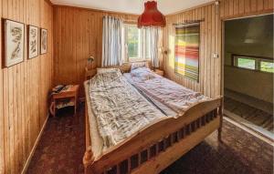 ein Schlafzimmer mit einem Bett in einer Holzwand in der Unterkunft Gorgeous Home In verkalix With Kitchen in Överkalix