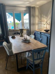 a dining room with a wooden table and chairs at la villa du clos avec "spa" in Cayeux-sur-Mer