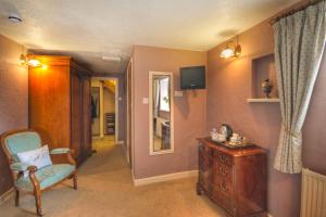 a living room with a chair and a dresser at Tinhay Mill in Lifton