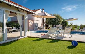 a patio with two chairs and a table and an umbrella at Nice Home In Stratincica With Wifi in Vela Luka