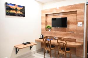 THE M K HOTEL -Luxury In Style في Chās: غرفة مع مكتب مع كرسيين وتلفزيون