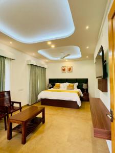 - une chambre avec un grand lit et une table dans l'établissement Tea & Sky Munnar, à Munnar