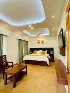 a bedroom with a large bed and a table at Tea & Sky Munnar in Munnar