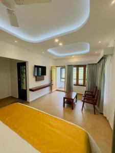 - une chambre avec un grand lit jaune dans l'établissement Tea & Sky Munnar, à Munnar
