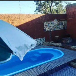 una gran bañera azul en un patio junto a una pared en Casa Roma Cidade Ocidental, en Cidade Ocidental