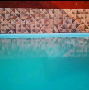 un reflejo de una pared en una piscina en Casa Roma Cidade Ocidental, en Cidade Ocidental