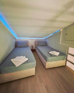 two beds in a small room with blue lights at Stone Villa in Pythagoreio