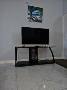 a flat screen tv sitting on a stand in a room at The Cherryhill of Old Harbor in Old Harbour