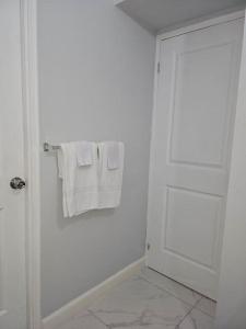 a bathroom with white towels and a white door at The Cherryhill of Old Harbor in Old Harbour